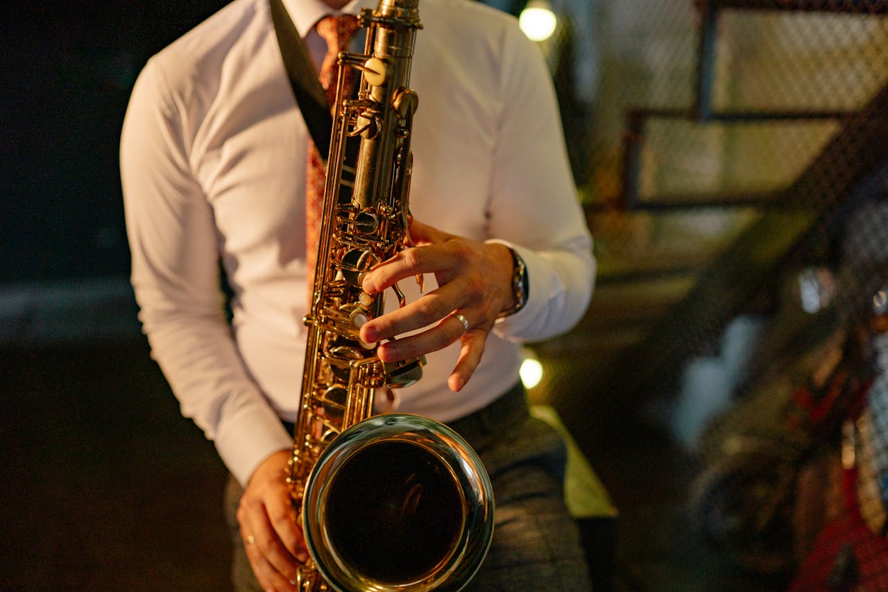 A musician in formal attire plays the saxophone indoors, showcasing musical talent.